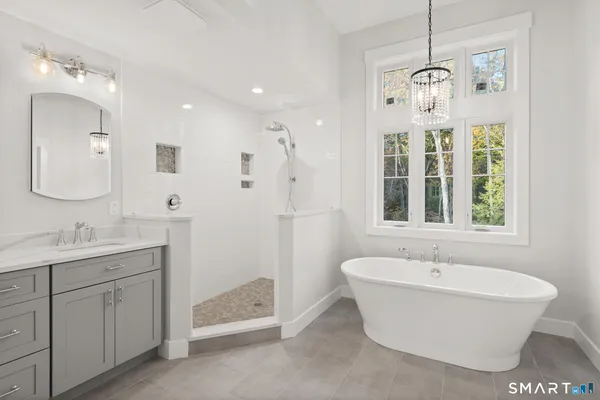 a view of a bathroom with a bathtub sink and mirror