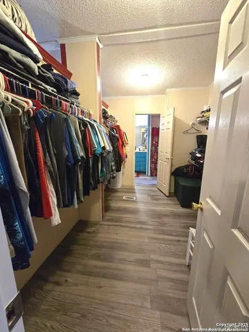 a view of walk in closet with clothes and shoes