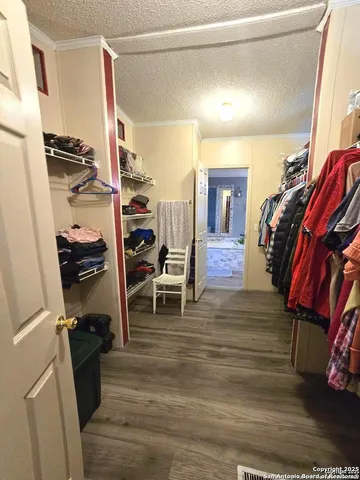 a view of walk in closet with clothes and shoes