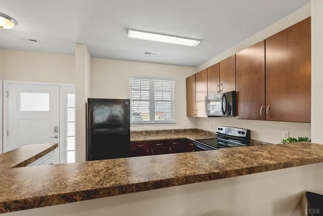 a kitchen with granite countertop a refrigerator and a sink