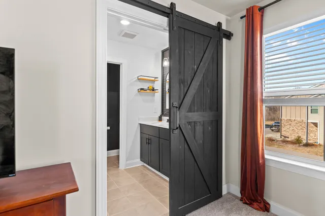 a bedroom with a bed a couch and a large window