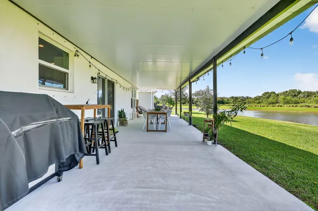 a couple of table and chairs with the view of balcony