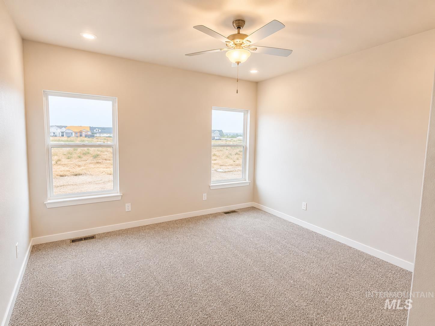 983 Quartz Road Kimberly, ID 83341 - Photo 8 of 18 Carpeted room featuring two windows, a ceiling fan with integrated lighting, and recessed lighting