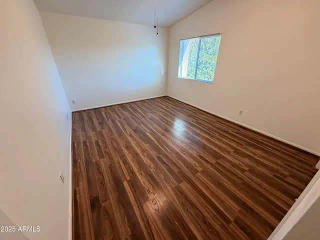 a view of a room with wooden floor and window