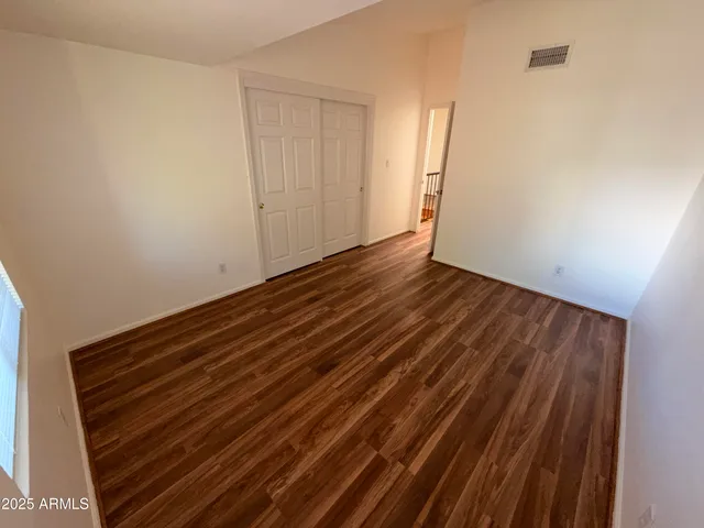 a view of empty room with wooden floor