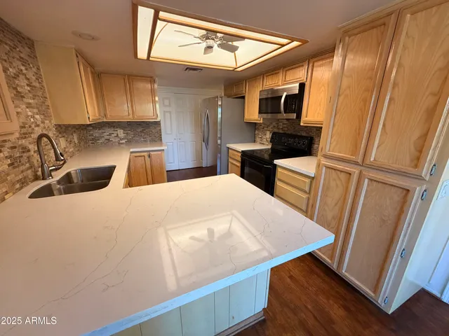 a kitchen with a sink a microwave a refrigerator and cabinets