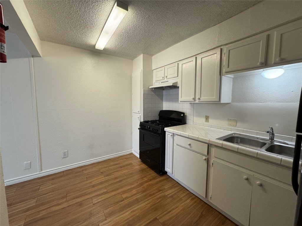 4810 West Wind Trail, Unit 101 Austin, TX 78745 - Photo 4 of 21 a kitchen with a sink cabinets stainless steel appliances and a window