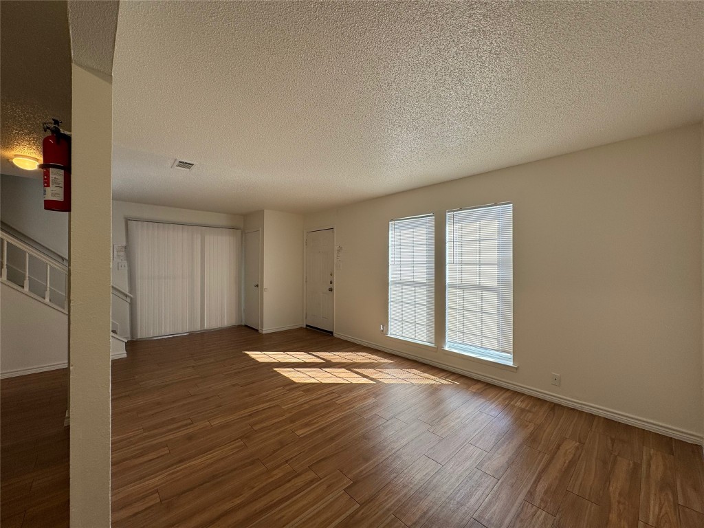 4810 West Wind Trail, Unit 101 Austin, TX 78745 - Photo 6 of 21 a view of an empty room with wooden floor and a window