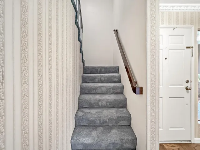 a view of staircase with white walls and white door