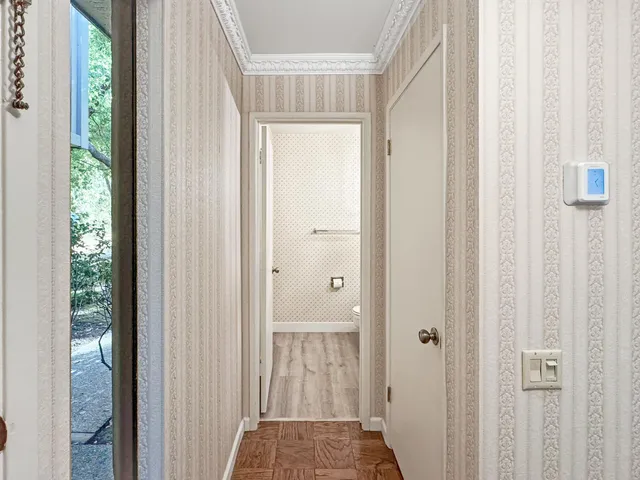 a view of a hallway with a ceiling fan and window