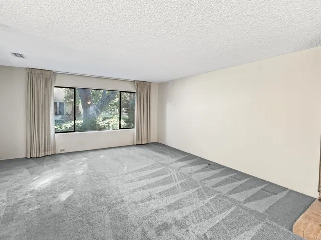 a view of an empty room with window and doors