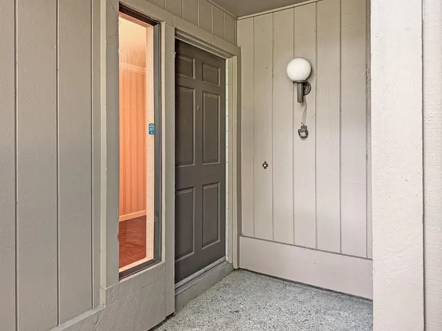 an empty room that has a window and wooden door