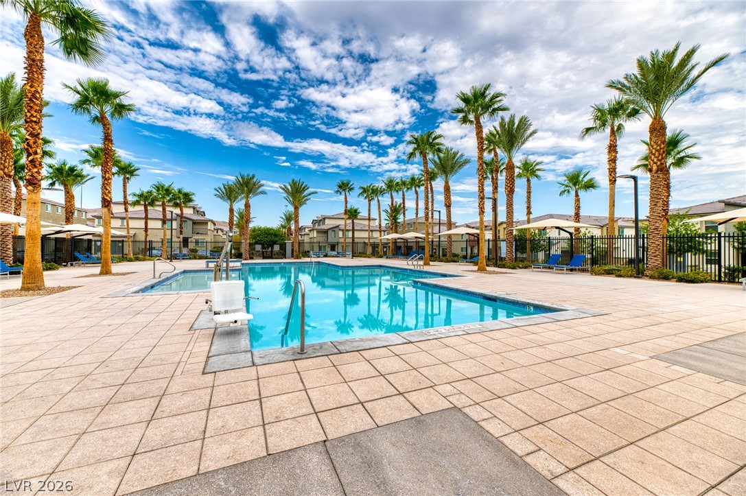 12105 Scarlet Ember Road, Unit 2 Las Vegas, NV 89183 - Photo 19 of 24 A refreshing pool awaits, surrounded by swaying palm trees and inviting lounge areas.