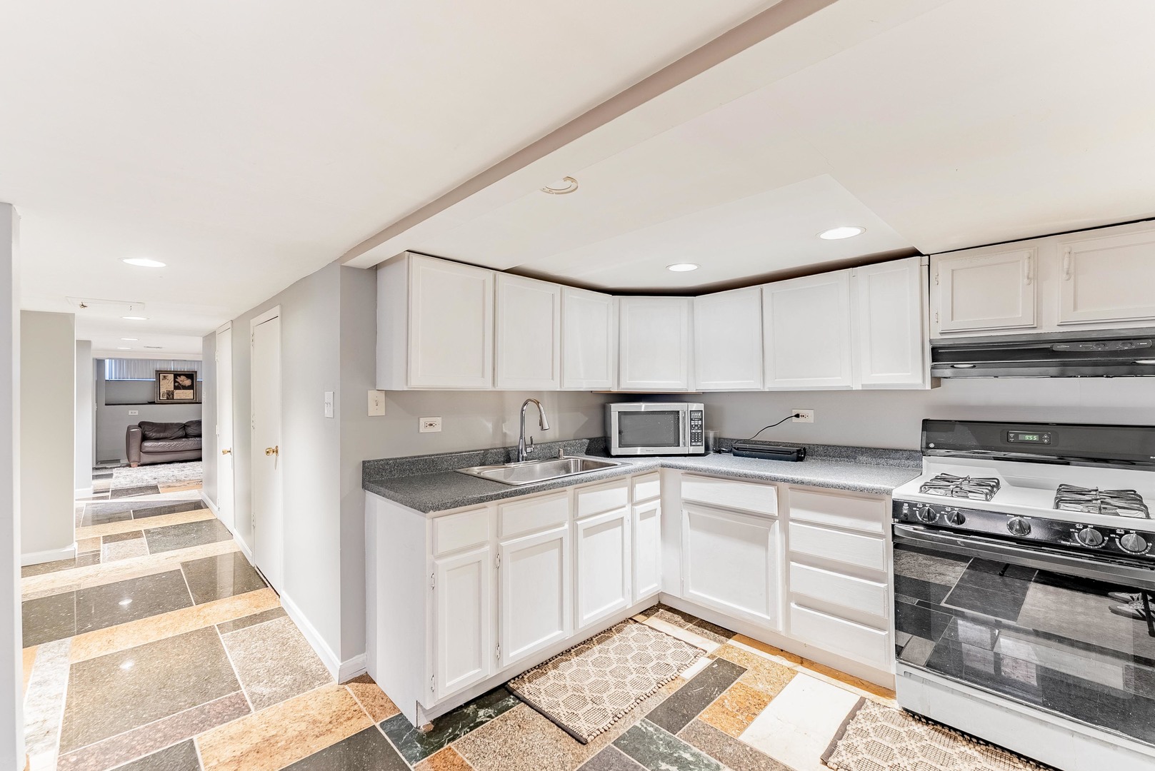 6031 South Normandy Avenue Chicago, IL 60638 - Photo 18 of 26 a kitchen with a sink stove and cabinets