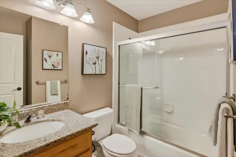a bathroom with a granite countertop sink toilet and shower
