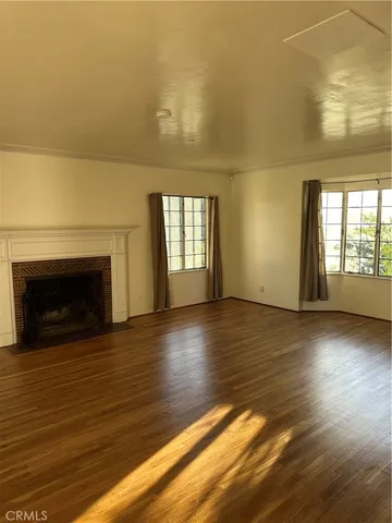 an empty room with wooden floor and fireplace