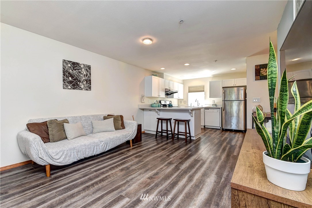 1311 North 145th Street, Unit B Seattle, WA 98133 - Photo 11 of 31 a living room with furniture and a dining table with kitchen view
