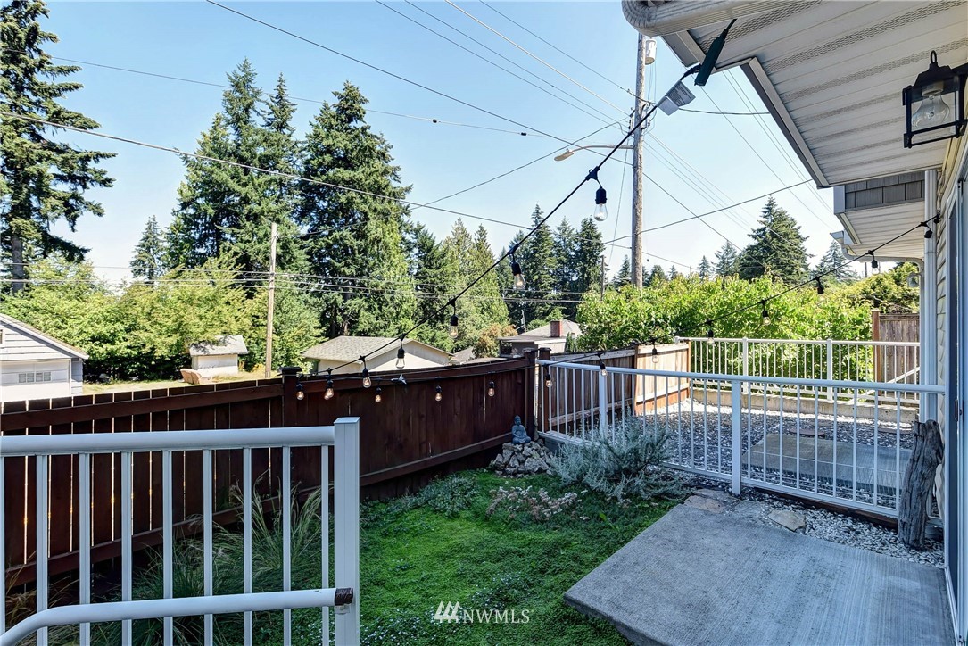 1311 North 145th Street, Unit B Seattle, WA 98133 - Photo 25 of 31 a view of a deck with a floor to ceiling window and wooden fence