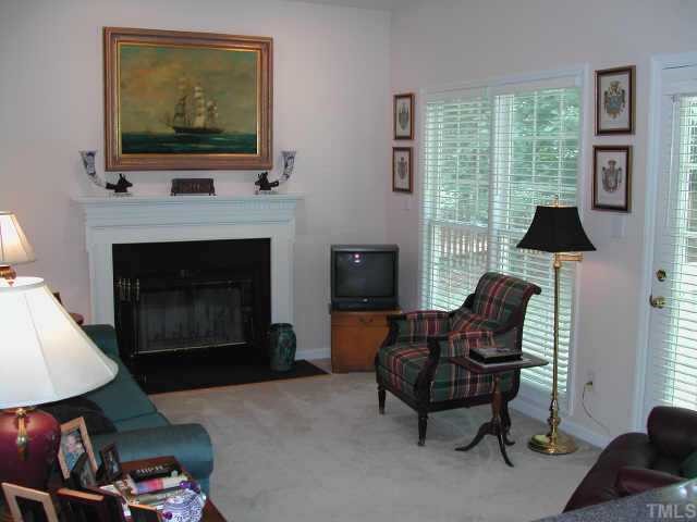 2505 Clerestory Place Raleigh, NC 27615 - Photo 6 of 10 a living room with furniture a flat screen tv and a fireplace