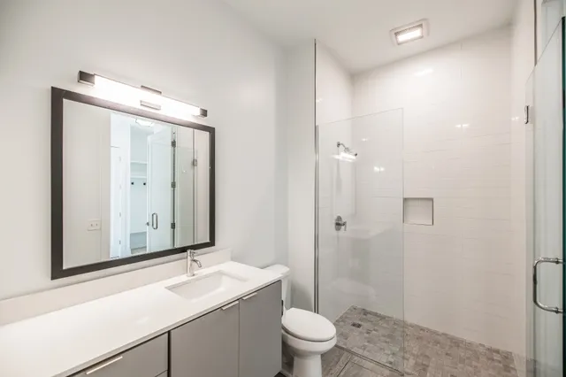 a bathroom with a sink a toilet and shower