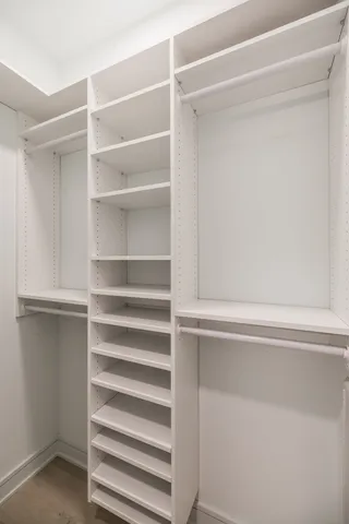 a view of walk in closet with empty racks