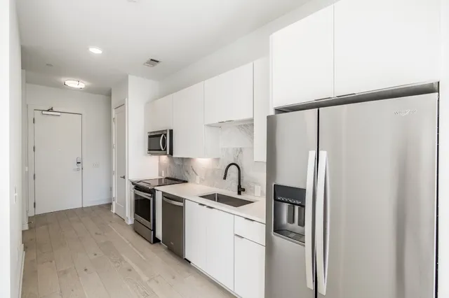 a kitchen with stainless steel appliances granite countertop a refrigerator and a sink