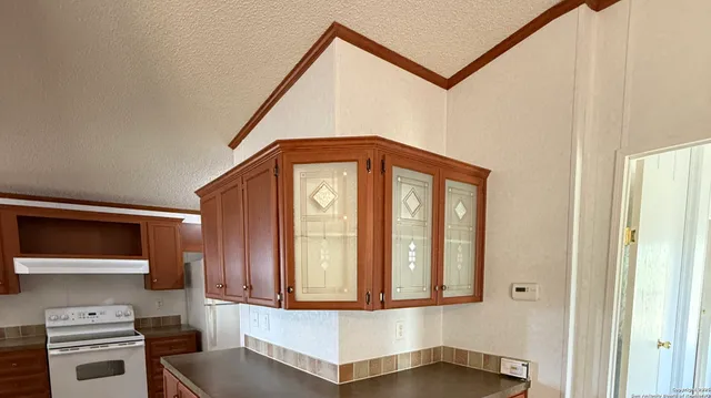 a view of a hallway with entryway a stove and a microwave