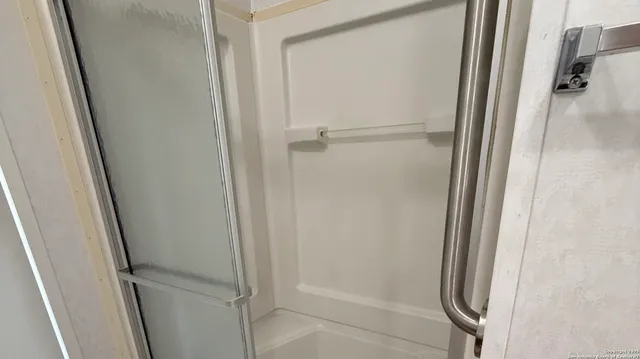 a bathroom with a tub shower vanity and a sink