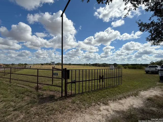 a view of a yard with wooden fence