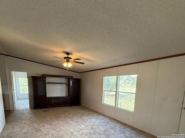 an empty room with windows and fireplace