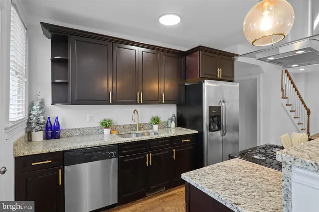 a kitchen with stainless steel appliances granite countertop a sink stove and refrigerator