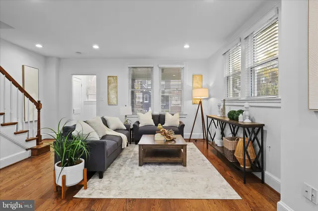 a living room with furniture and a wooden floor