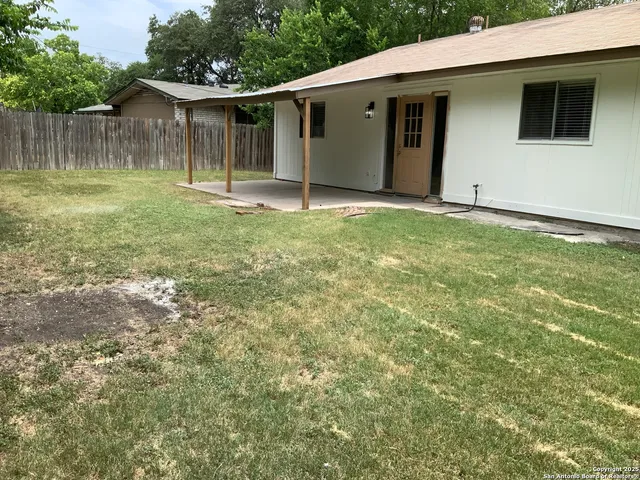 a backyard of a house with table and chairs