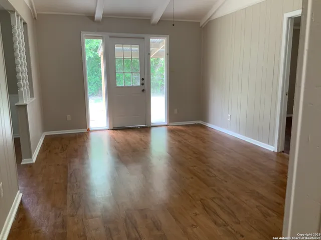 an empty room with wooden floor and a window