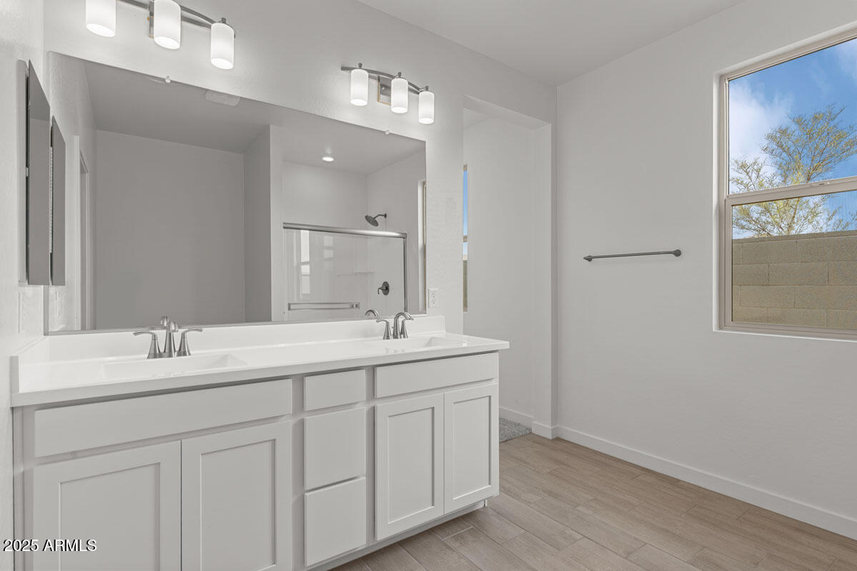 18168 West Pima Street Goodyear, AZ 85338 - Photo 16 of 21 a bathroom with a double vanity sink and mirror