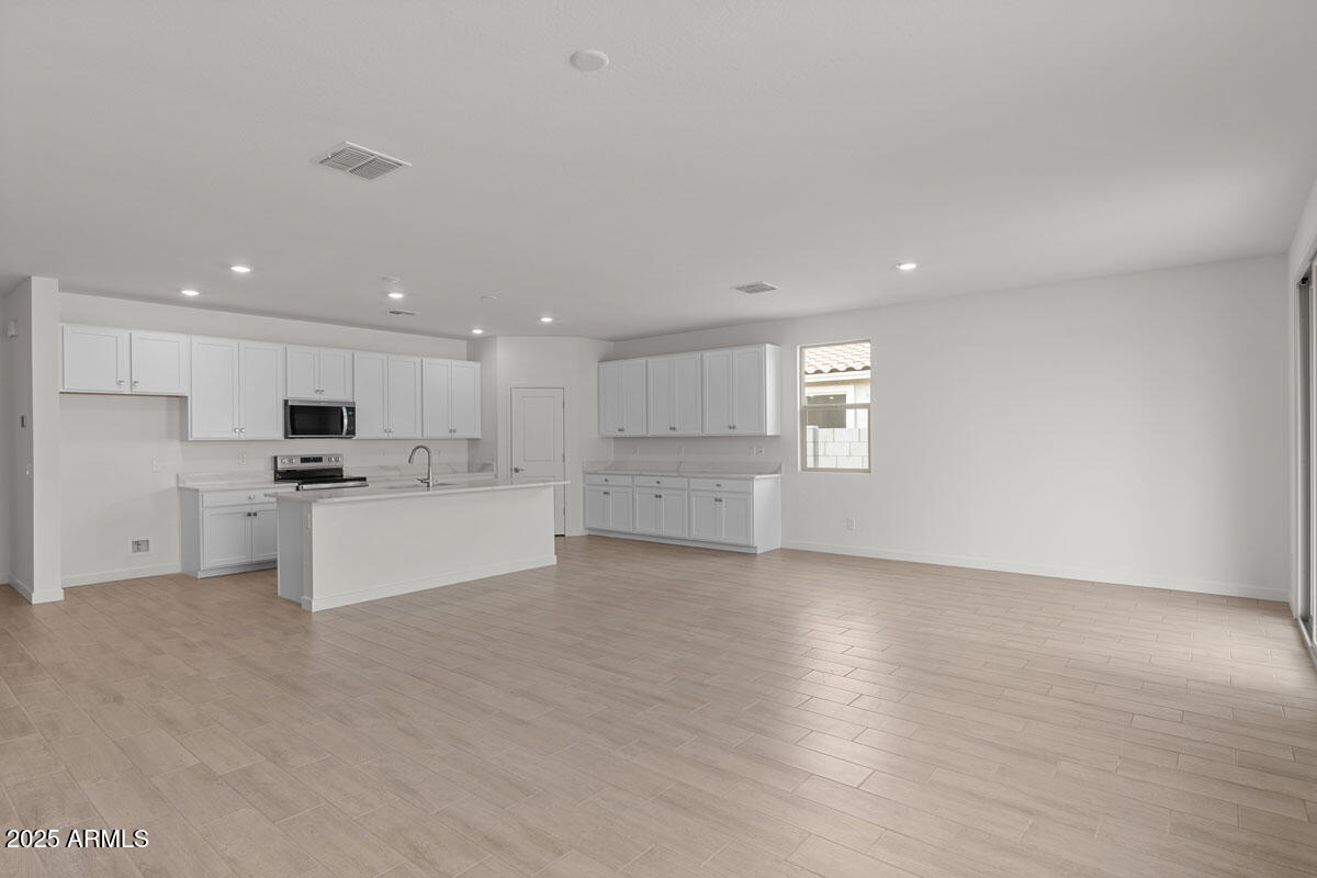 18168 West Pima Street Goodyear, AZ 85338 - Photo 2 of 21 a view of kitchen with wooden floor and windows