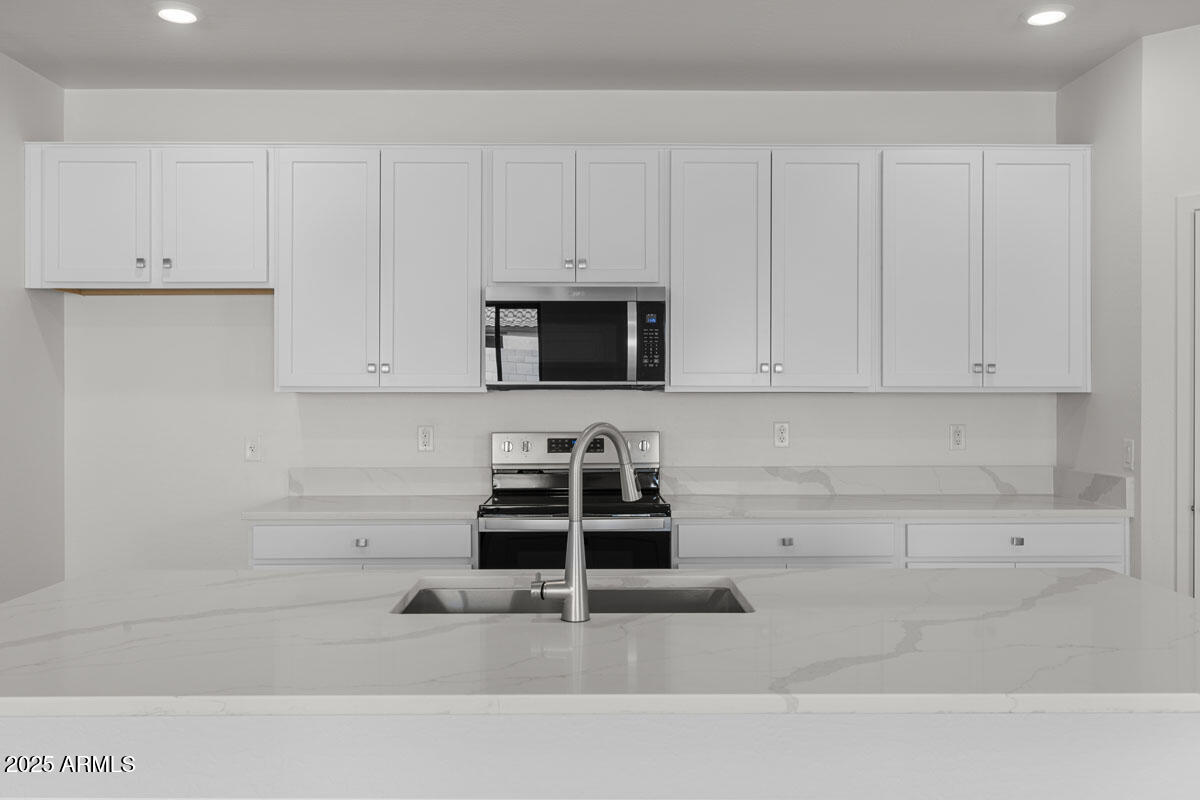 18168 West Pima Street Goodyear, AZ 85338 - Photo 5 of 21 a kitchen with white cabinets and sink