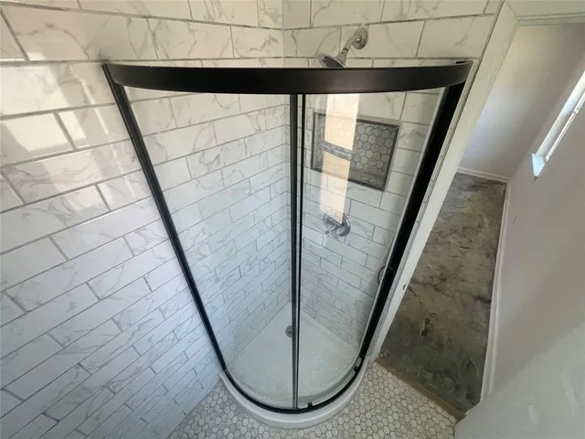 a bathroom with a sink a toilet a mirror and shower