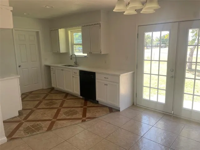 a kitchen with white cabinets and a sink