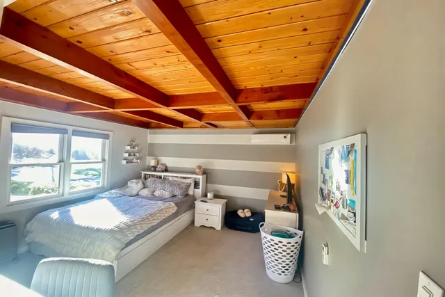 a bed sitting in a bedroom next to a window