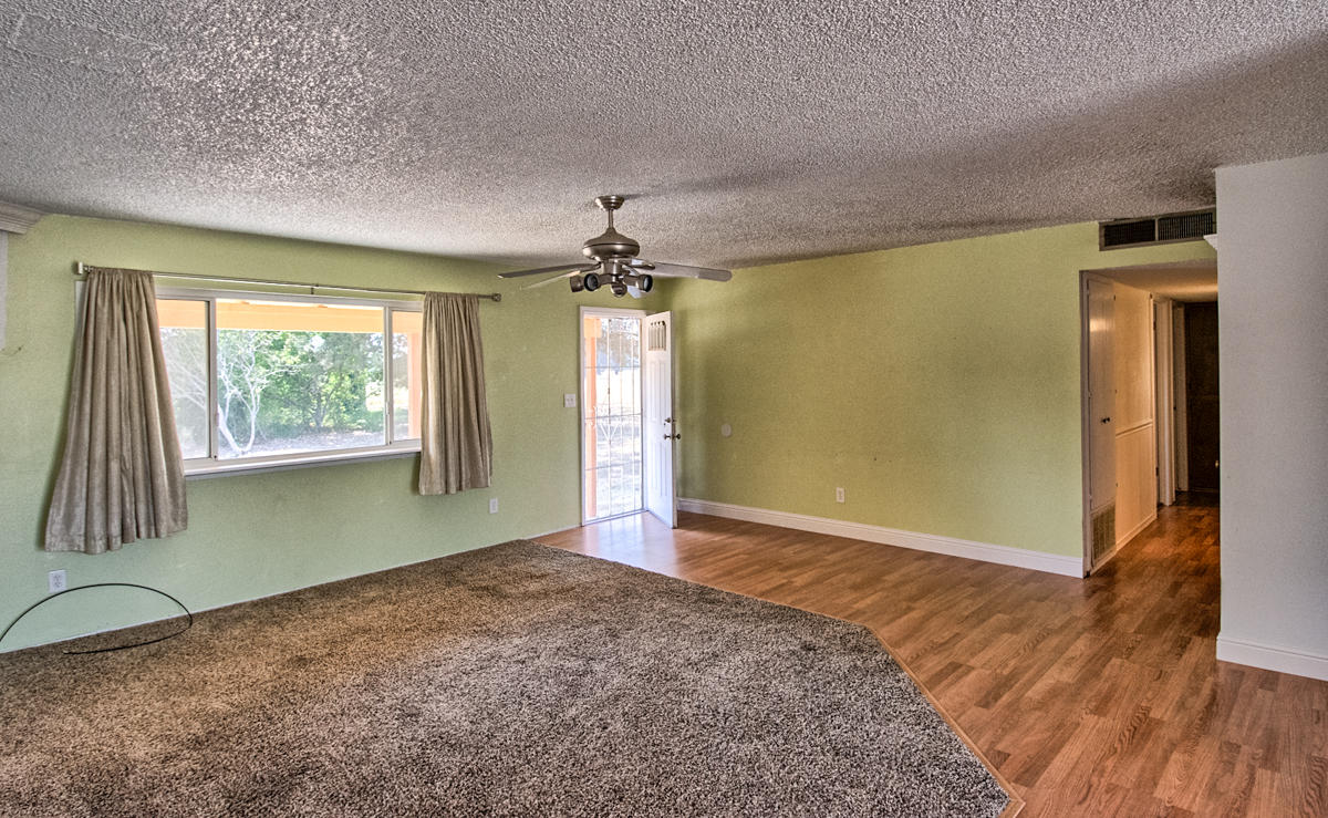 20458 Womack Road Red Bluff, CA 96080 - Photo 3 of 20 an empty room with wooden floor and windows