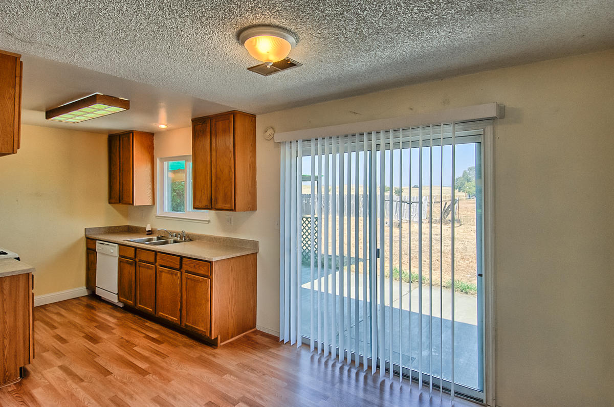 20458 Womack Road Red Bluff, CA 96080 - Photo 6 of 20 a kitchen with stainless steel appliances granite countertop a stove and a wooden floors
