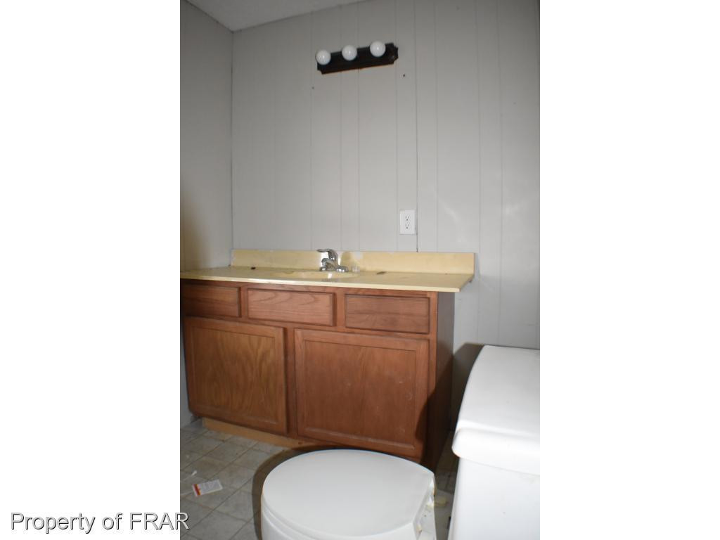 216 R Sands Road Carthage, NC 28327 - Photo 20 of 28 a bathroom with a toilet a sink and mirror