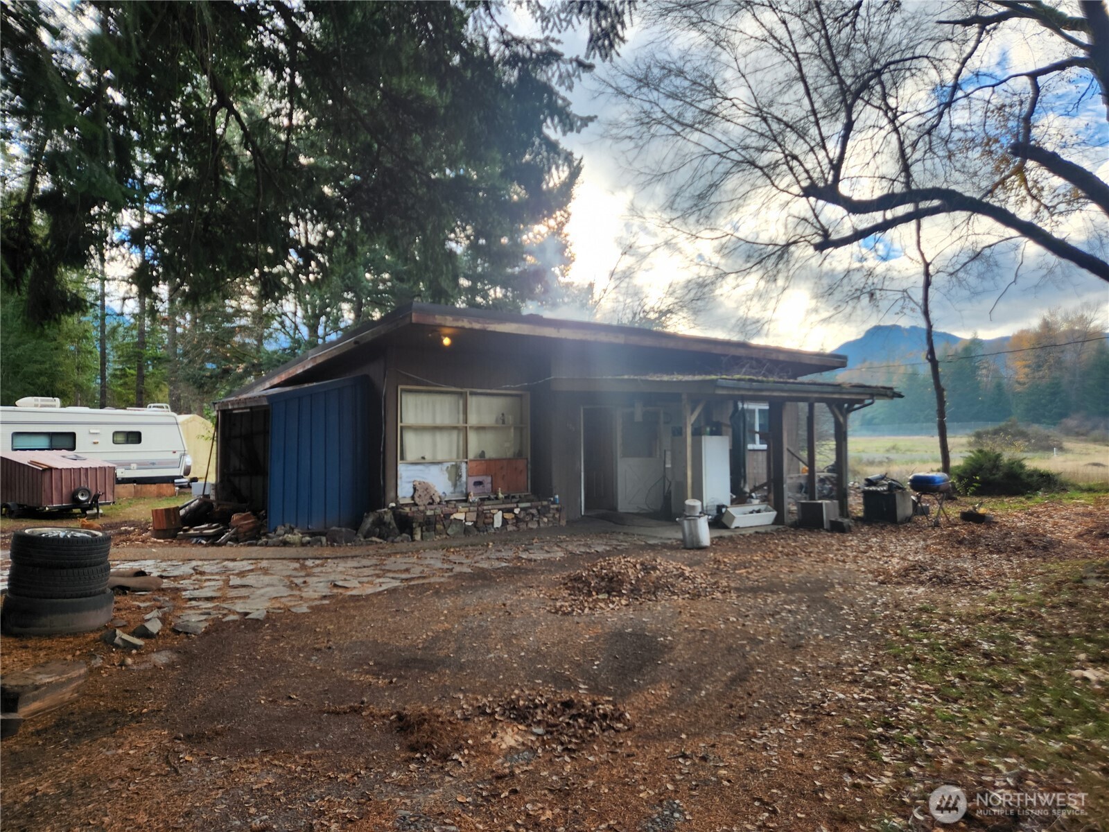 125 Edmonds Road Packwood, WA 98361 - Photo 2 of 6 a backyard of a house with barbeque oven fire pit table and chairs