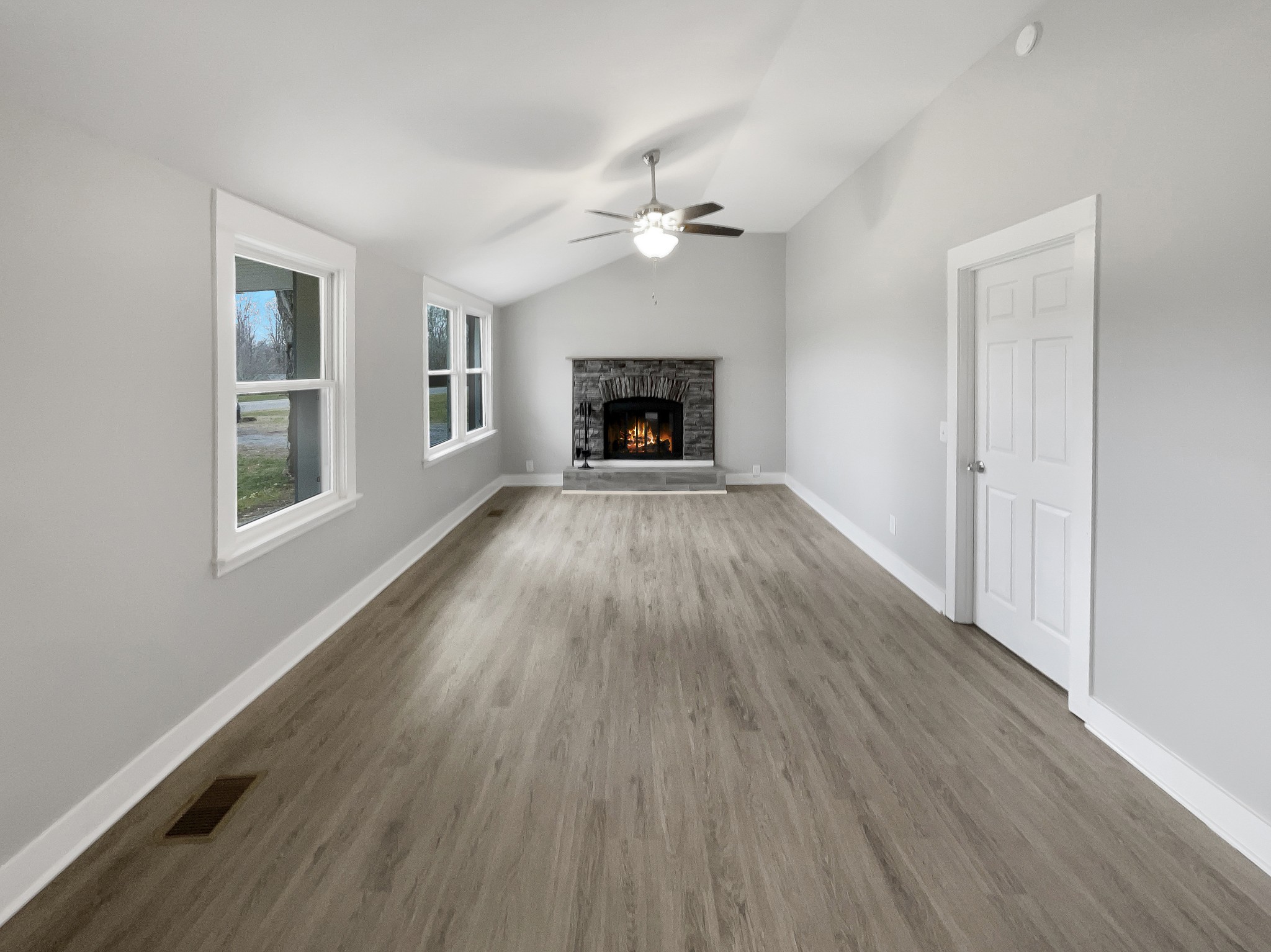 310 Tom Link Road Cottontown, TN 37048 - Photo 4 of 44 an empty room with wooden floor fireplace and windows