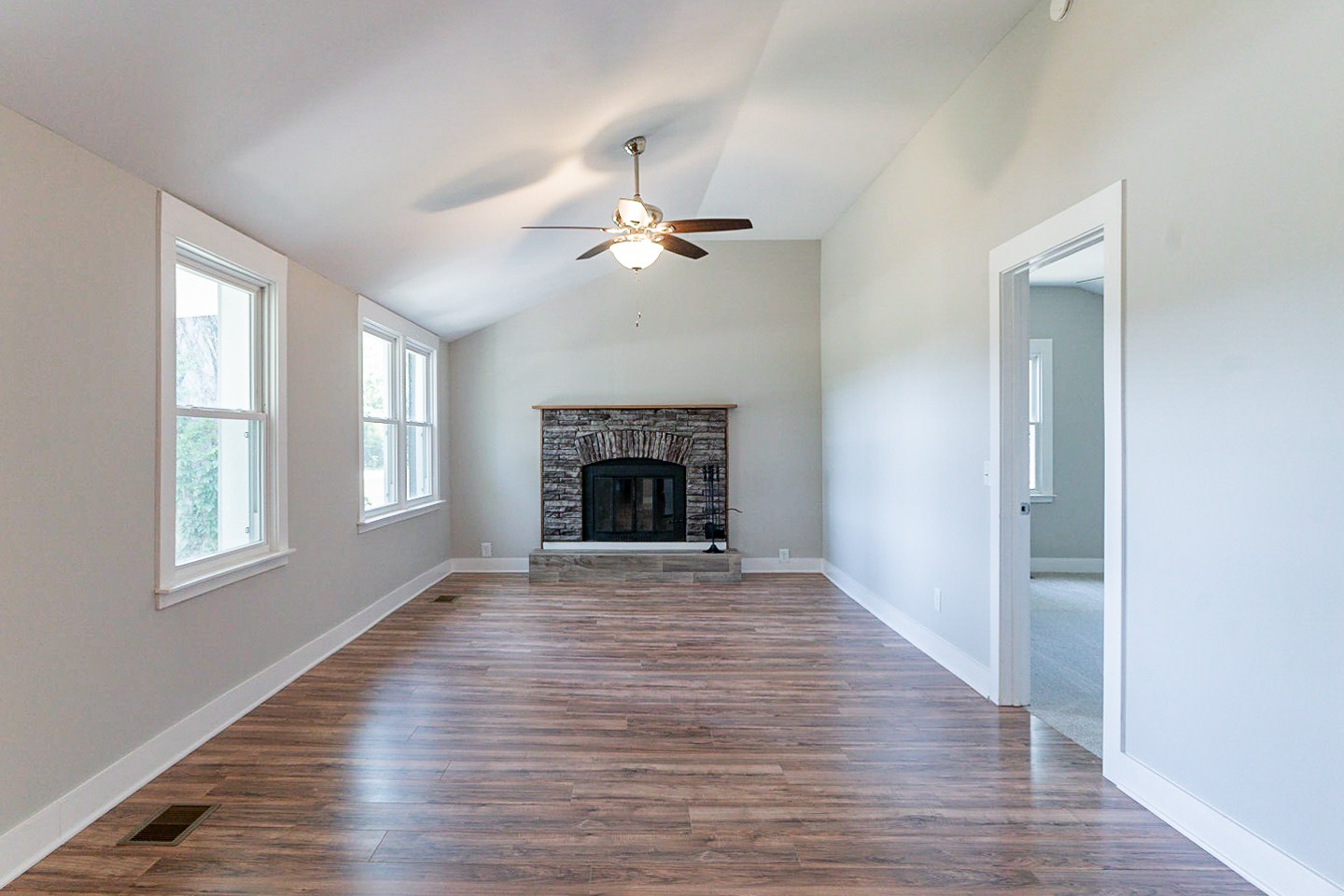 310 Tom Link Road Cottontown, TN 37048 - Photo 5 of 44 an empty room with wooden floor fireplace and windows