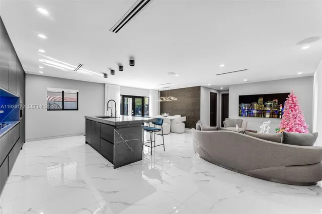 a large kitchen with stainless steel appliances a large counter top a stove and a sink