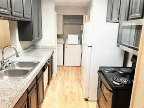 a kitchen with granite countertop a sink stove and refrigerator