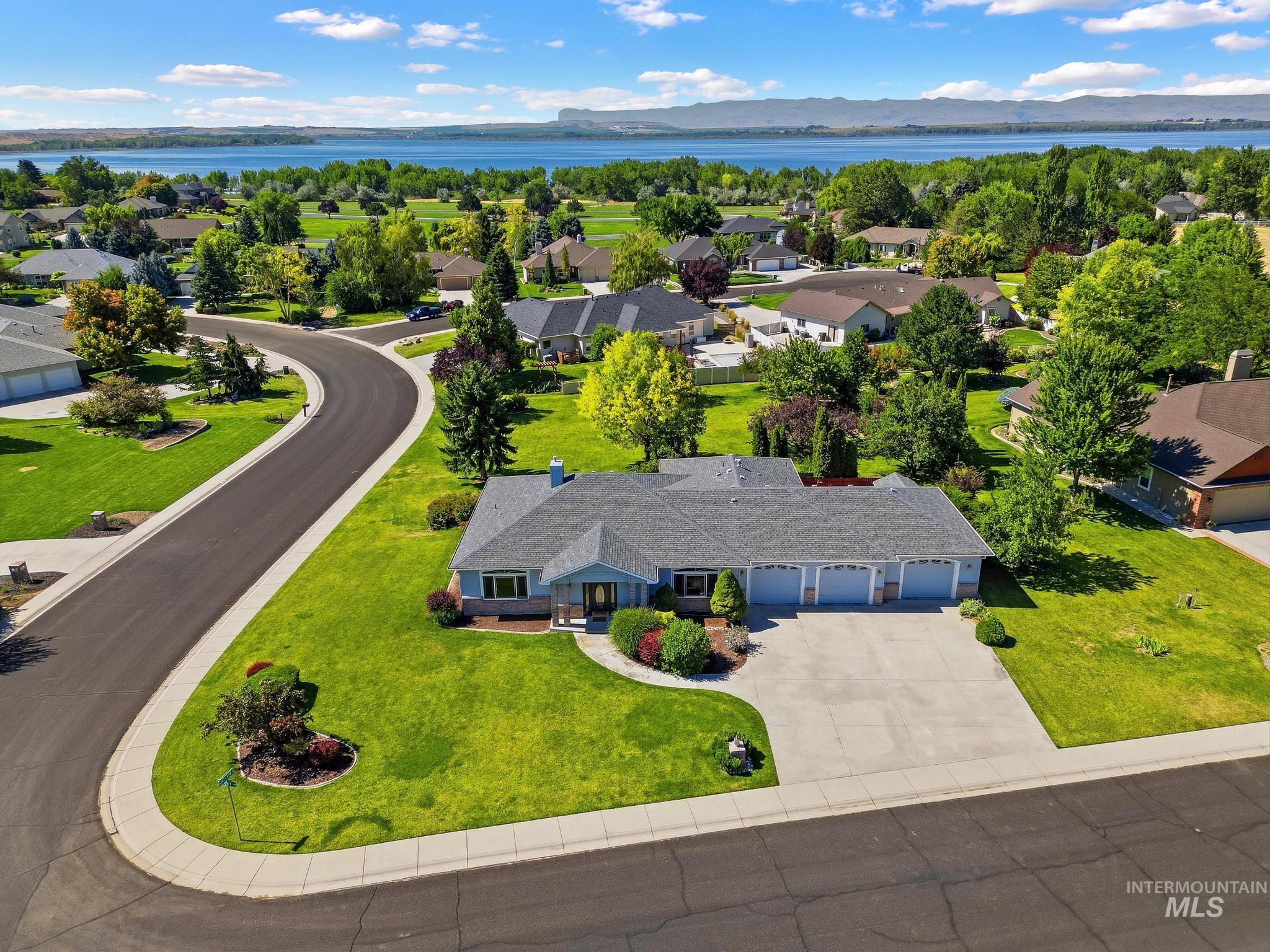 15181 Drury Way Caldwell, ID 83607 - Photo 33 of 49 Light blue siding exterior with a dark gray shingle roof and a three-car garage