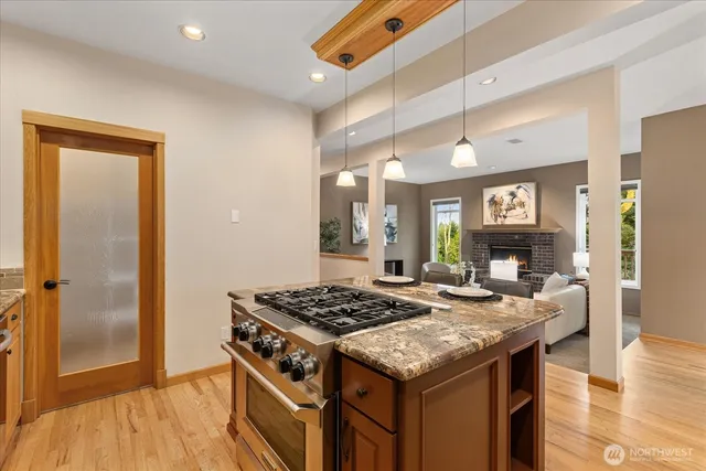a kitchen with a stove and a wooden floor